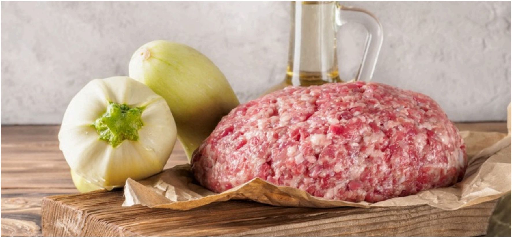 Berkshire blend ground meat on a wooden board with vegetables