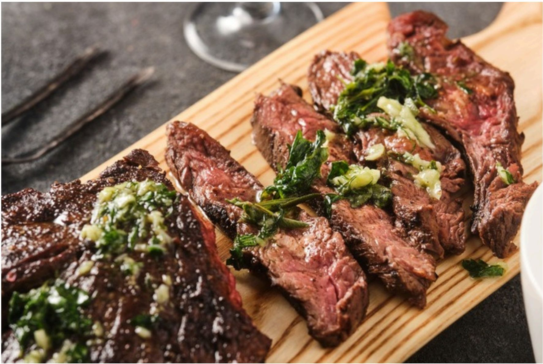 Sliced cooked hanger steak on a wooden board
